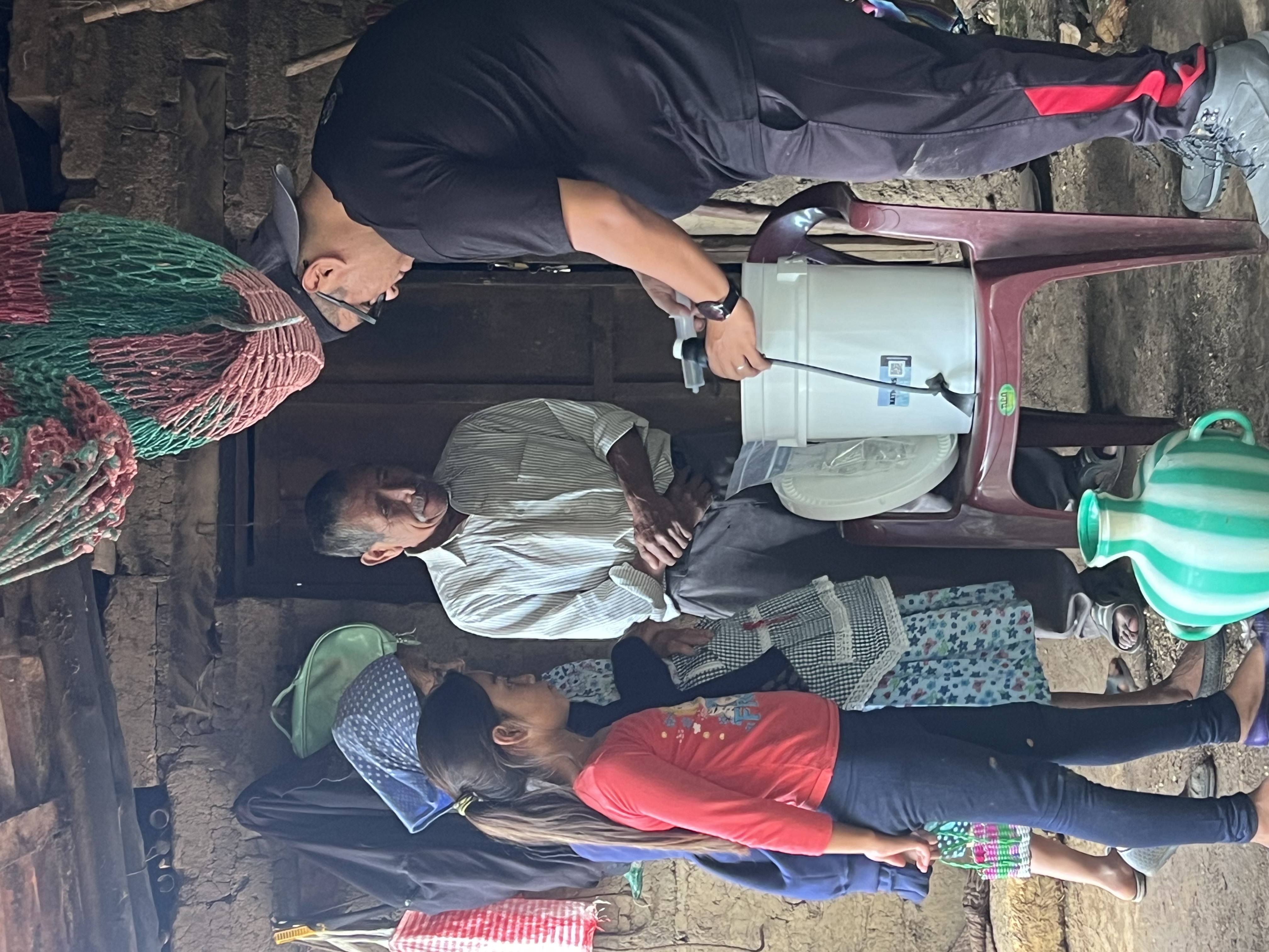 A team member installing a water filter with a family in their home