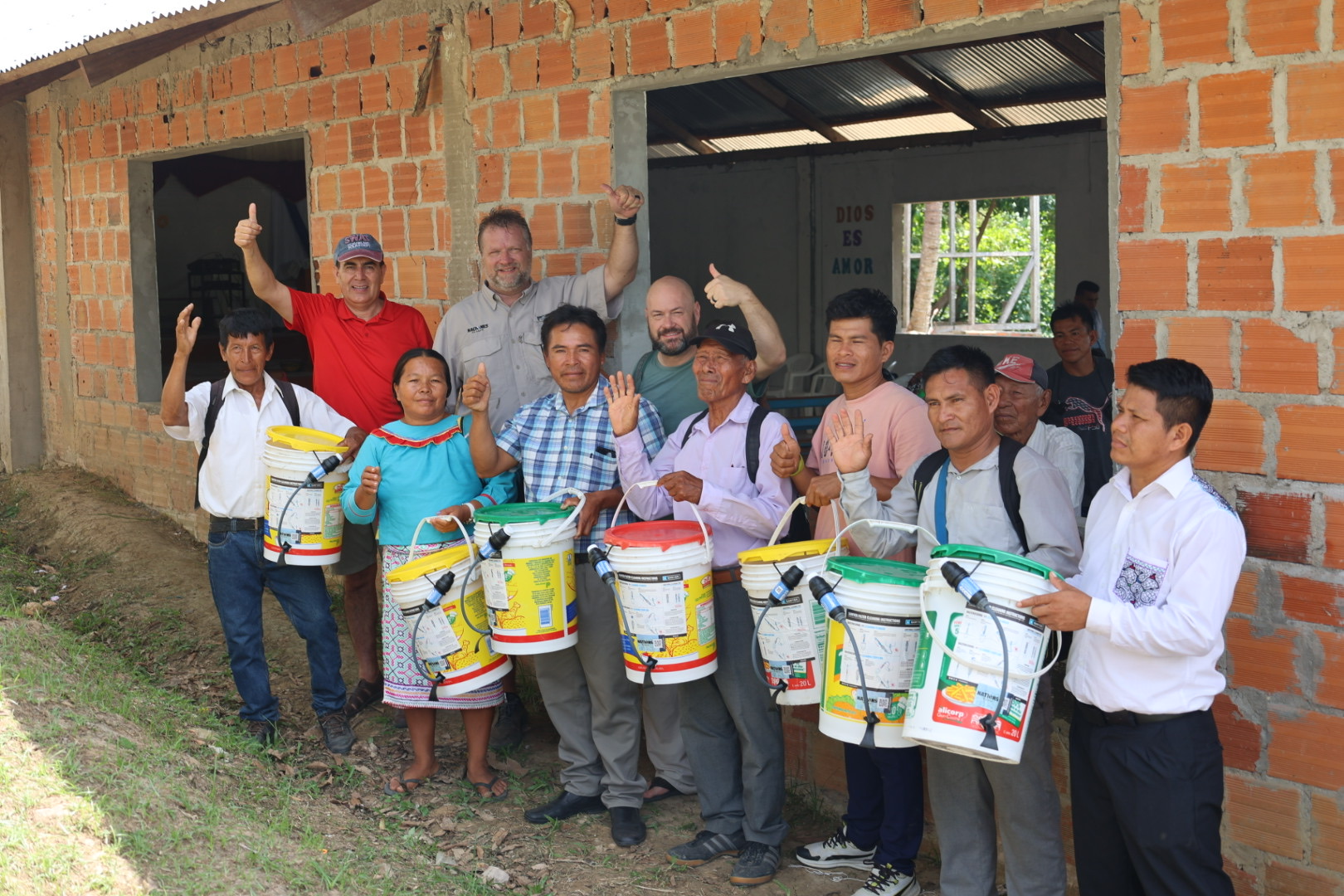 Local leaders with newly delivered water filters outside a community building